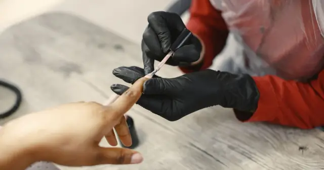 Manicure aplicando esmalte em gel